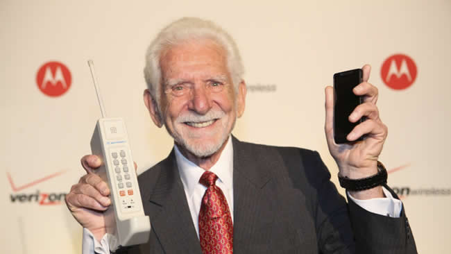 Martin Cooper of Motorola holding first cell phone.